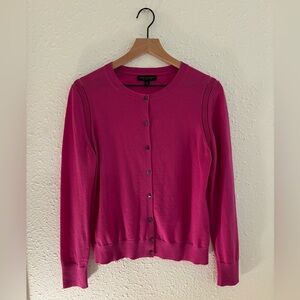 Long sleeve merino wool magenta cardigan. Abalone-like buttons.